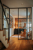 Home office behind glass wall with brick wall and leather armchair