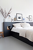 Modern bedroom with black bed frame and picture wall