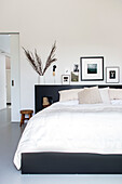 Bedroom with modern, black and white wall decor and minimalist bed