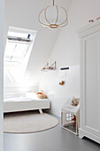 Bright, minimalist children's room with skylight, playhouse and round rug