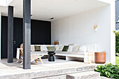 Modern covered terrace with lounge seating area and white and green pillows