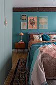 Bedroom with turquoise-colored wall and nature motifs on the wall