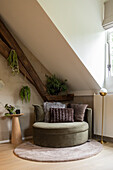 Round velvet armchair in the loft, flanked by plants and floor lamp