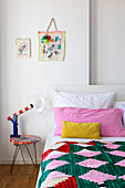 Colourful bedroom with colourful bedspread and decorative elements