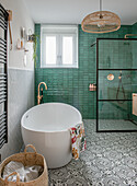 Freestanding bath and shower in green tiled bathroom