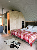 Bedroom with vaulted ceiling, small, wood-paneled room with sliding door