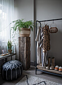 Rack with clothes and shoes, plants in modern bedroom