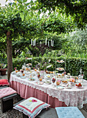 Tea party in the garden with cakes and pastries on a decorated tablecloth