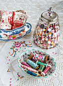 Sewing accessories: buttons in a jar, spools of thread, fabric and embroidery on a crochet blanket