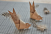 DIY birds made from brown paper with dotted feathers on cutting mat