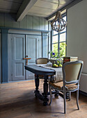 Dining area in shades of blue and grey with wooden table and upholstered chairs