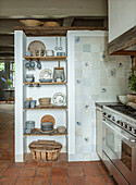 Open kitchen shelves with crockery, tiles with blue floral patterns