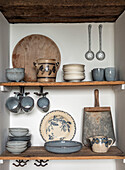 Vintage kitchen shelf with ceramic crockery and wooden board