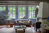 Country-style living room with fireplace and blue-painted wooden windows