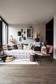 Living room in earthy tones with sofa, pink chair and dog