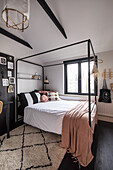 Bedroom with black and white colour scheme and metal four-poster bed