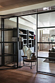 View through glazed doors to side table with white porcelain vases