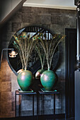 Large green vases with peacock feathers in the modern entrance area