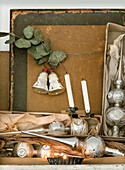 Silver Christmas tree toppers in old boxes, bells and candles