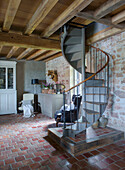 Antique spiral staircase in the living room with terracotta tiled floor and wooden beamed ceiling