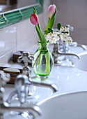 Tulip (Tulipa) and lily of the valley (Convallaria majalis) in a vase on a washstand