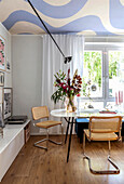 Dining area with round marble table and woven chairs in modern design