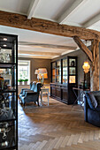 Rustic living room with exposed wooden beams and herringbone parquet flooring