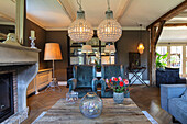 Rustic living room with fireplace, velvet armchairs and crystal chandeliers