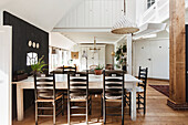 Country-style dining area with wooden table and black chairs