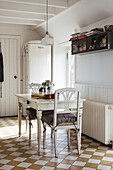 Bright dining room with white table, chairs and chequered floor tile pattern