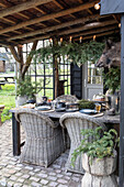 Rustic outdoor dining area with rattan chairs and natural decorations