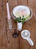 Wooden table with candlesticks, vase and bowls