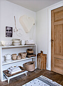 Open shelf with ceramic crockery and baskets