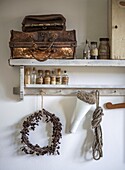 Vintage shelf with antique suitcase, bottles and decorations