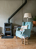 Cozy reading corner with fireplace and blue wing chair