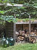 Wood storage, glass bottles and basket in the garden