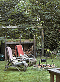 Seating area with rattan armchairs and fire pit in the garden