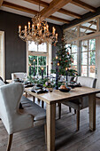 Set dining table with Christmas tree, chandelier and black candles