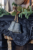 Historic fireplace with Christmas decorations and two pewter bells