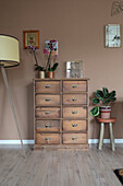 Wooden drawer unit with flowers and vintage-style floor lamp