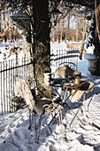 Table set under a tree in the snow