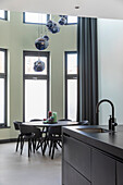 Dining area with black table and modern glass pendant lamps