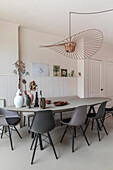 Dining room with large table, Scandinavian chairs and modern decorative elements