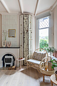 Bright living room with rattan armchair and fireplace