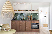 Modern wooden kitchen with green tiled backsplash and dining area