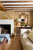 Living room with beamed ceiling, fireplace and antique mirror