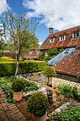 Historic courtyard with stone wall, hedges and plants