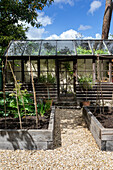 Gartenhaus mit Glasdach, Hochbeete im Sommer