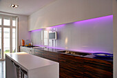 Galley kitchen white with purple lighting and island