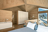 Modern bedroom with wood panelling and mountain views